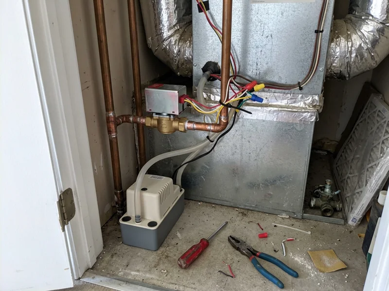 New motorized zone valve and condensate pump installed in a fan coil closet